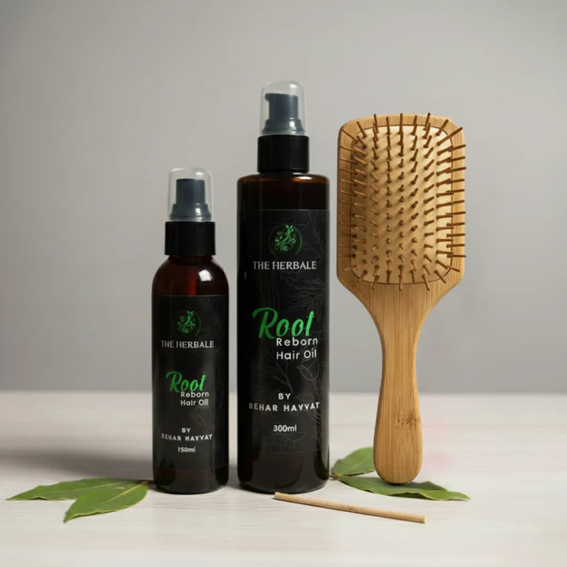 Root Reborn Hair Oil by Sehar Hayvat - 150ml and 300ml bottles displayed with a bamboo hairbrush and fresh leaves, highlighting the natural ingredients for healthy and stronger hair.