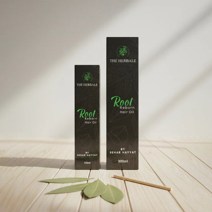 Root Reborn Hair Oil by Sehar Hayvat - 150ml and 300ml boxes placed on a wooden surface with fresh leaves, showcasing the natural hair oil packaging and its premium quality ingredients.